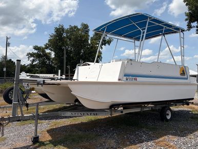 White pontoon boat on a trailer outdoors.