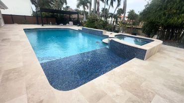 Modern backyard pool with a raised hot tub and blue mosaic tiles.
