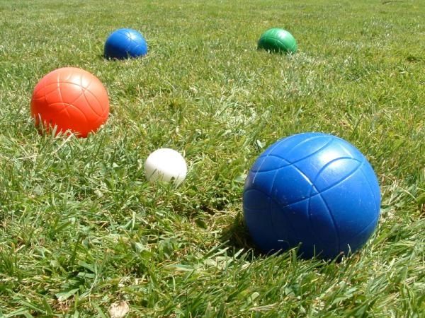 Colored bocce balls on grass with a white pallino.
