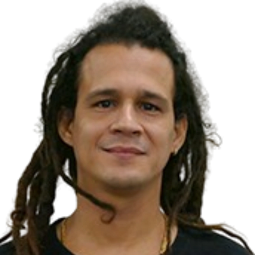 Man with long dreadlocks and black shirt smiling gently.