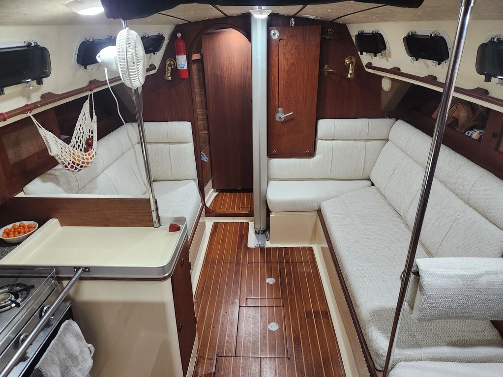 Cozy sailboat cabin with wood accents and cushioned seating.