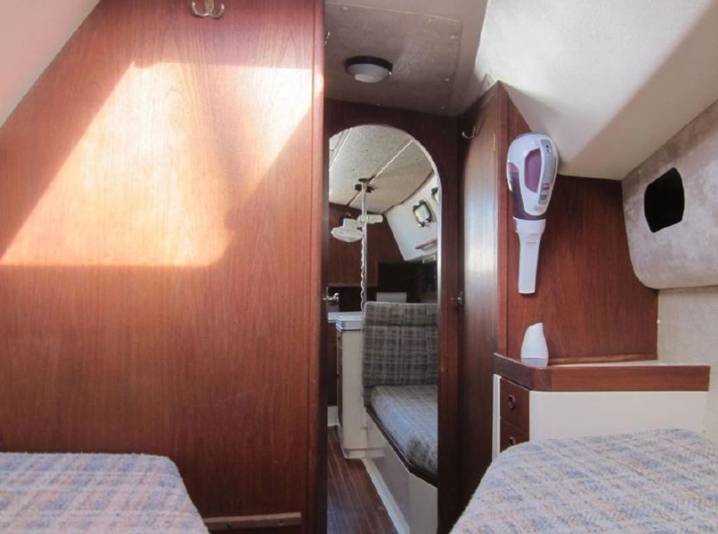 Cozy boat cabin interior with wooden paneling and plaid cushions.