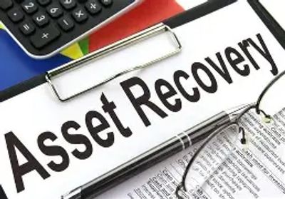 Document titled 'Asset Recovery' with glasses and a calculator nearby.