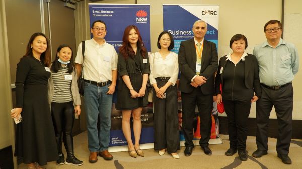 Group photo of eight professionals standing in front of business banners.