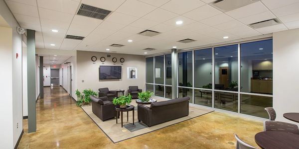 Modern office lounge with leather seating and glass walls.