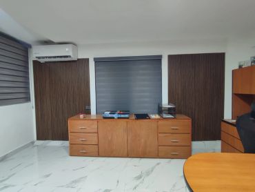 Modern office with wooden furniture and marble flooring.