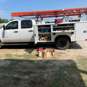 Work truck with equipment and open compartments.
