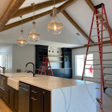 Modern kitchen with pendant lights and ladders.