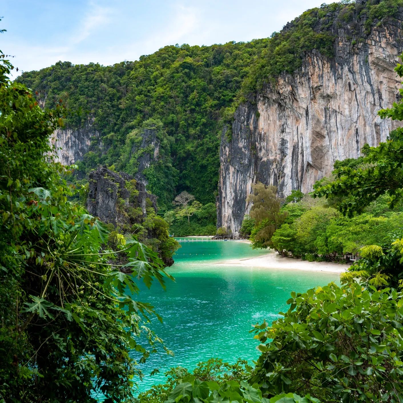 Tropical bay with turquoise water and limestone cliffs.
