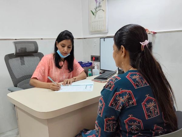 A doctor consulting a woman in a clinic office.
