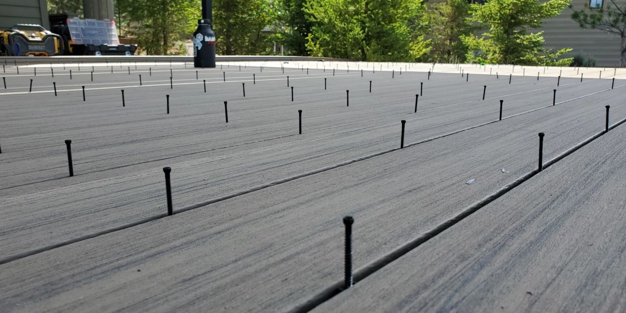 A deck with screws partially installed in the wood.
