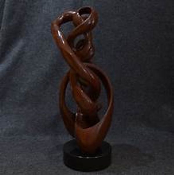 Intricately carved wooden abstract sculpture on a black base.