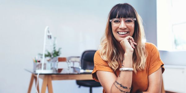 Photo of woman with hand on her chin smiling in her office. The photo is above information that  NMS