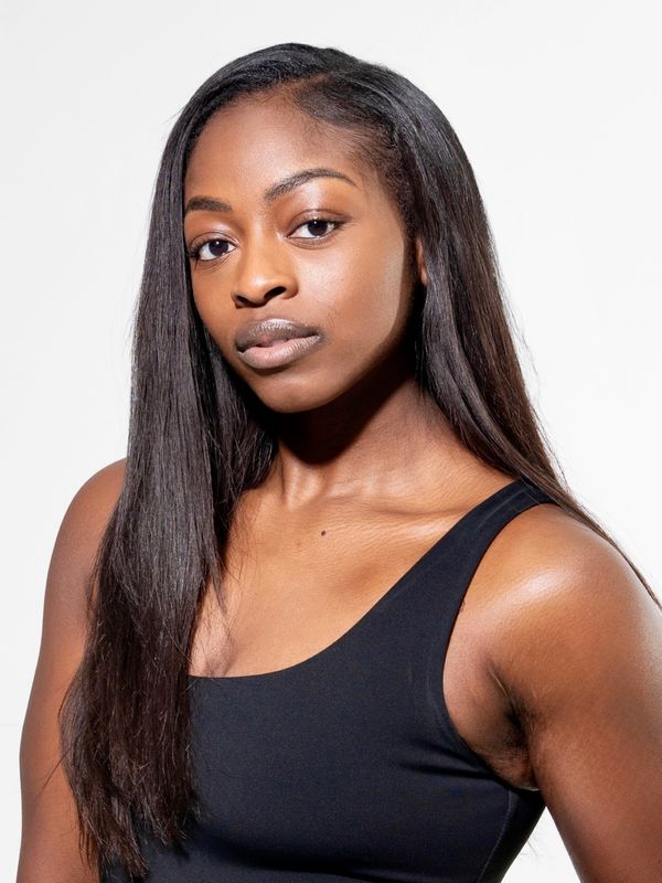 Confident woman with long straight hair wearing a black tank top.