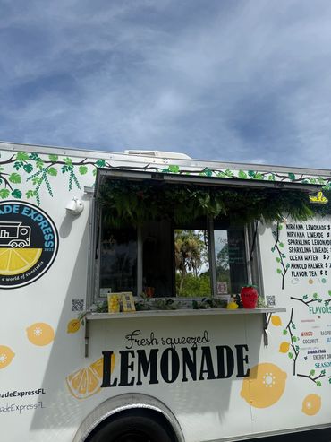 Colorful lemonade food truck under blue sky.