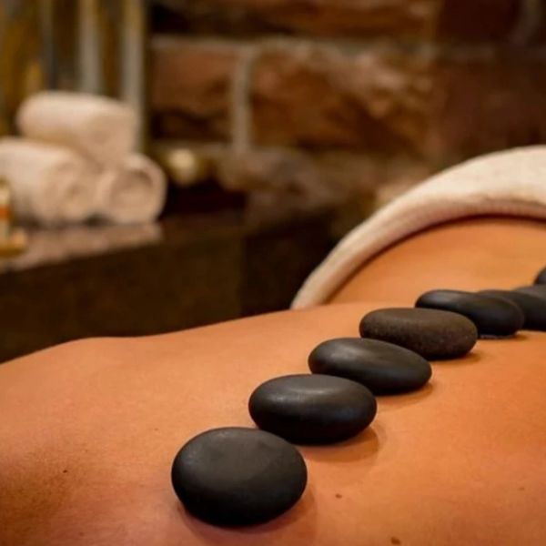 Hot stones lined up on a person's back for massage therapy.