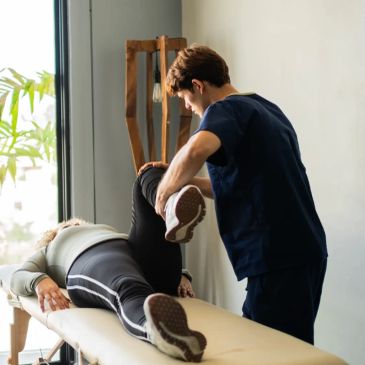 Physical therapist assisting a patient with leg stretch.