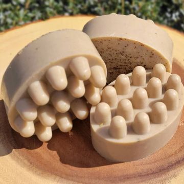 Brown Cucumber Mint & Seaweed Shampoo massage bars on a piece of round wood