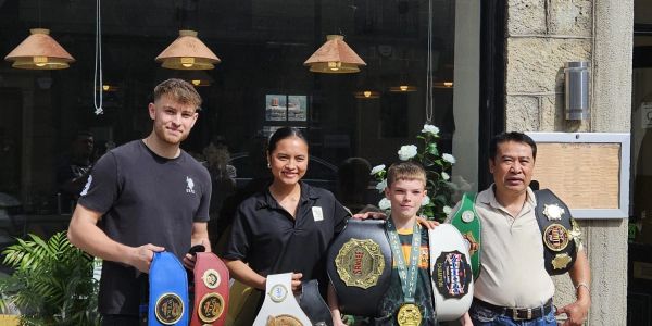 Four people posing with championship belts.