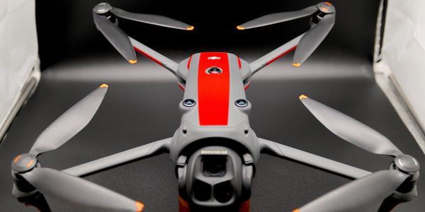 Close-up of a red and gray drone with four propellers.