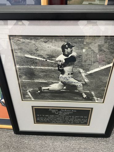 Framed black and white photo of Reggie Jackson hitting a baseball.