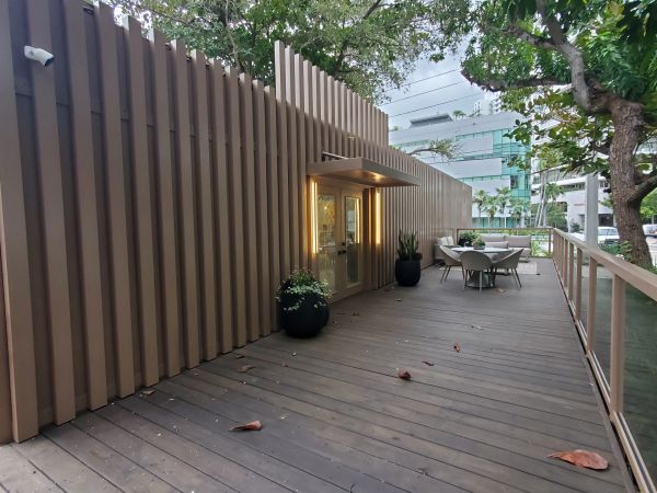 Modern outdoor patio with wooden deck and vertical slat wall design.