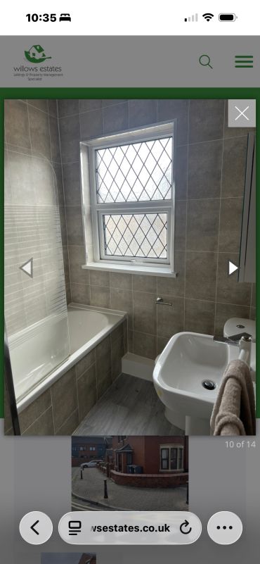Bathroom with bathtub, sink, and window.