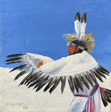 Native American dancer in traditional feathered regalia against blue sky.