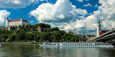 Danube river cruise boat in front of Bratislava Castle, Slovakia