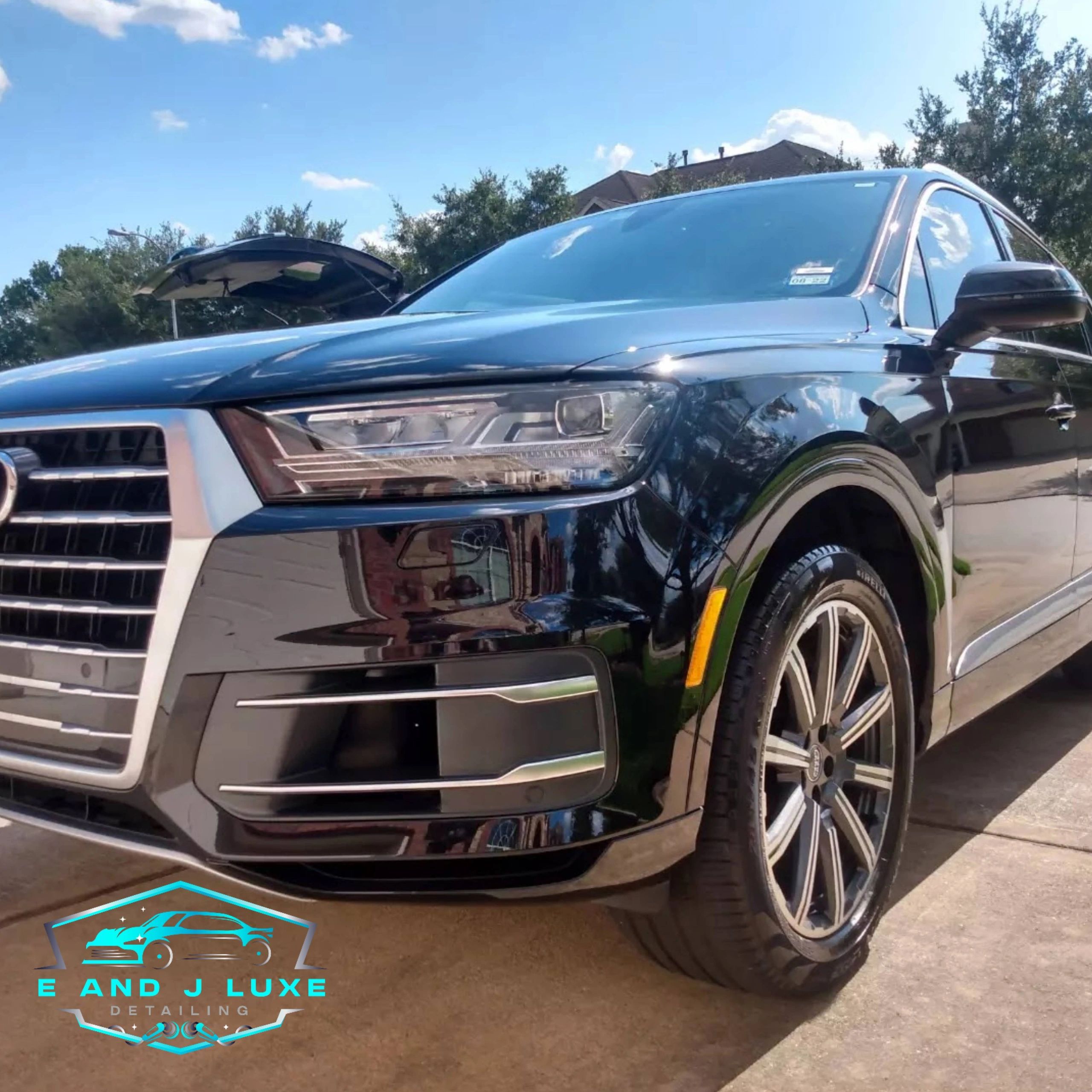 Shiny black Audi SUV with detailed clean finish under a clear blue sky.