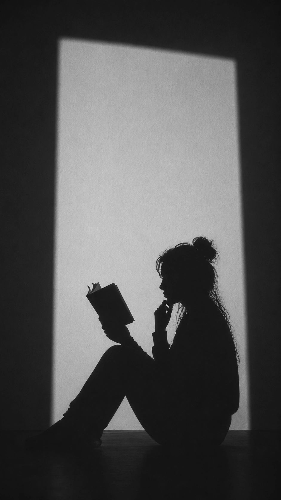 Silueta de una persona leyendo un libro.