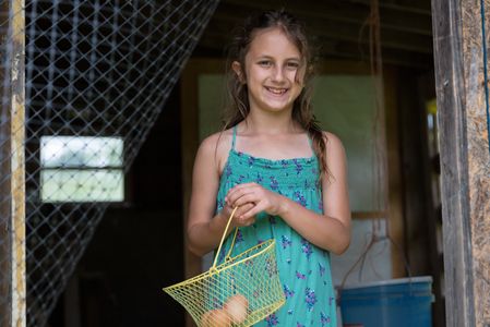 Riya helps collects eggs as one of her daily chores.  
Photo credit Kelley Lynch. 