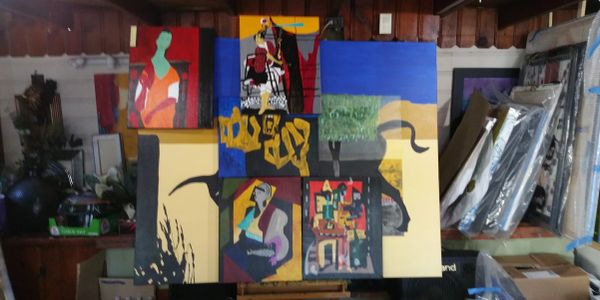 Colorful abstract paintings displayed in a dimly lit room.