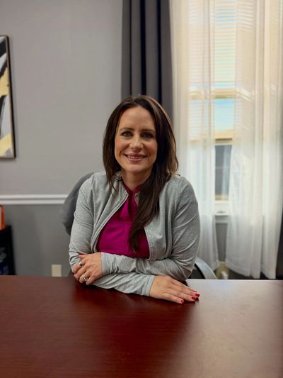Woman sitting at a desk smiling.
