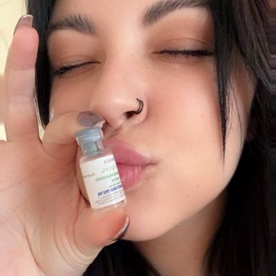 Woman holding and kissing a small vaccine vial.