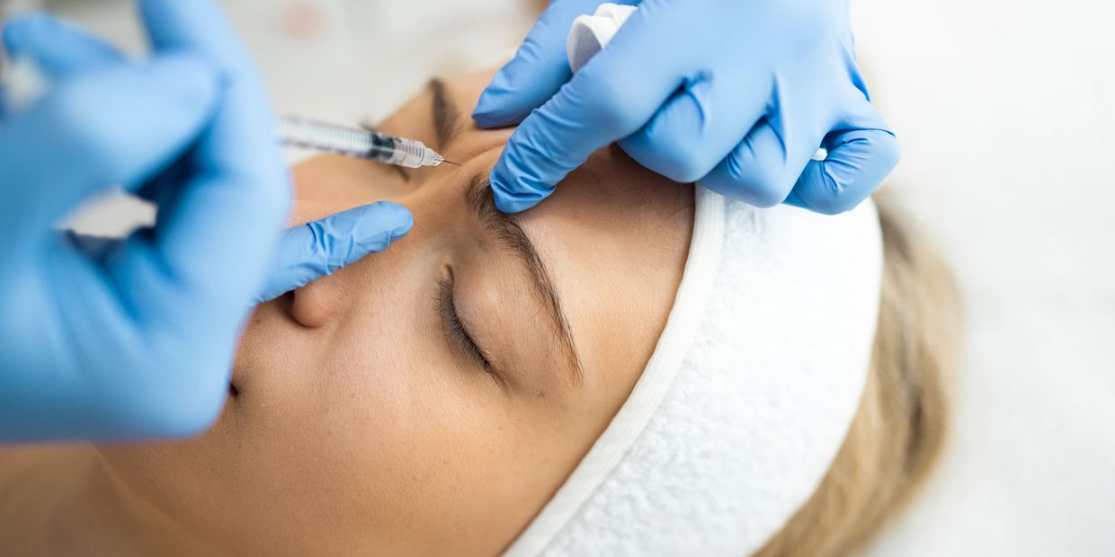 Person receiving a cosmetic injection on the forehead.