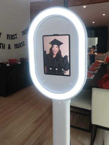 Ring light with phone displaying a graduating woman.