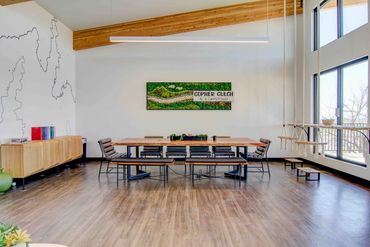 Modern, bright meeting room with long table and swings.