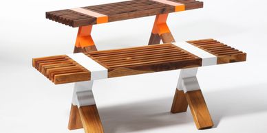 Modern wooden bench with orange and white accents.