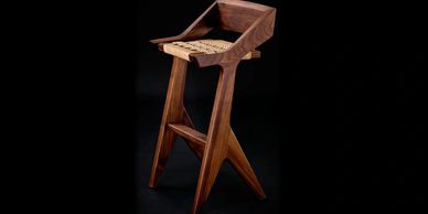 Modern wooden chair with a woven seat.