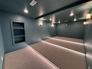 Empty room with green walls, carpeted floor, and built-in shelves.