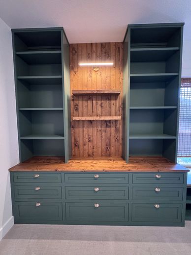 Green wooden cabinet with shelves and drawers.