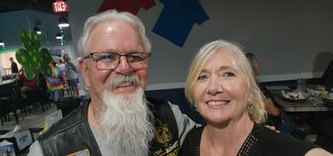 Smiling older couple posing together indoors at a social event.