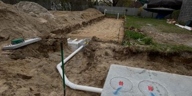 Construction site with plumbing pipes and dugout soil.