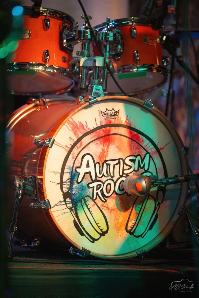 Close-up of a drum with colorful artwork and the words 'Autism Rocks'.