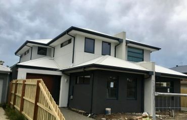 Modern two-story house under cloudy sky.