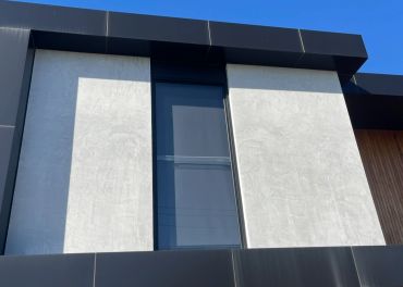 Modern building facade with black and white panels and vertical window.