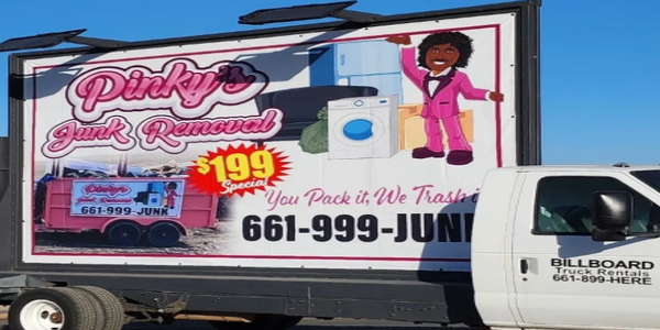 White billboard truck advertising Pinky's Junk Removal with a phone number.