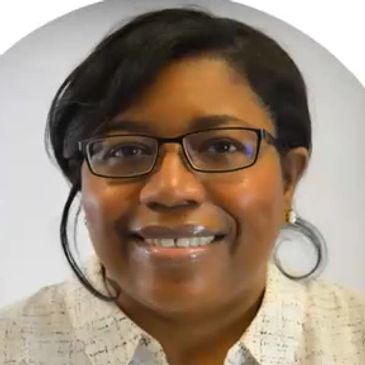 African American Women wearing black framed glasses & white collared shirt w/ muted abstract print