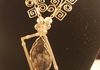Asymmetrical Astrophyllite cabochon is mounted diagonally in a gold filled wire frame which is hung from one corner from a handmade chain